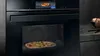 Bakoven met pizza binnen, keukenapparaat, voedselbereiding, koken, bakken, keukeninterieur.