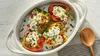 Stuffed bell peppers filled with rice, vegetables, and cheese, garnished with herbs.