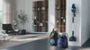 A sleek black vacuum cleaner stands on a polished floor, showcasing a modern living room.
