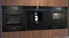Siemens kitchen with dark appliances, wooden cabinetry, and fresh fruit on the counter.