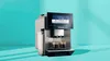Siemens Kaffeevollautomat mit Touchdisplay und zwei Espresso-Gläsern vor petrolfarbenem Hintergrund.