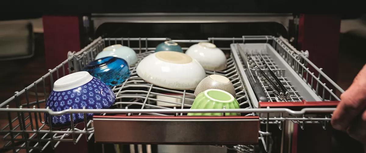 Geschirrspüler mit verschiedenen Geschirr, Schüsseln und Küchenutensilien.