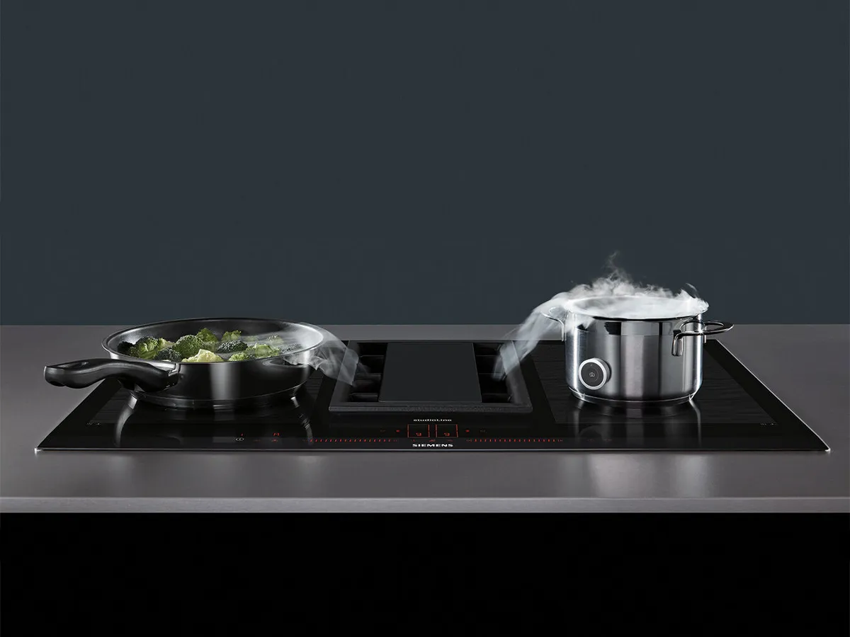 Yemek aletleri: ocak, buhar, yüzeyde taze yeşiller.