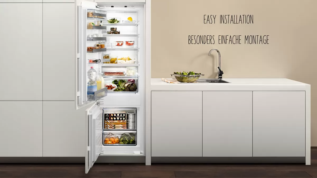 Offener Kühlschrank mit Lebensmittelartikeln, Küchentisch mit Spüle, Text "Easy Installation, einfache Montage" auf Deutsch.