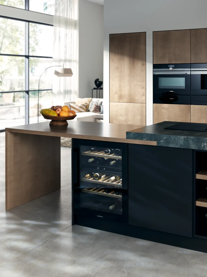 A sleek modern kitchen with two built in Siemens ovens stacked on top of each other.