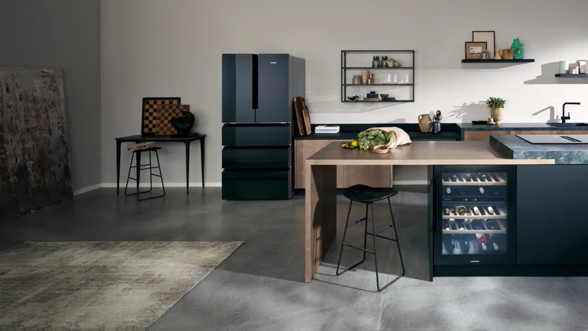 A modern kitchen with a dark grey Siemens French door refrigerator, a kitchen island with a wine cooler, and open shelving.