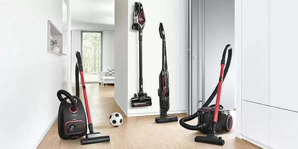 Three different types of vacuum cleaners displayed in a bright room.