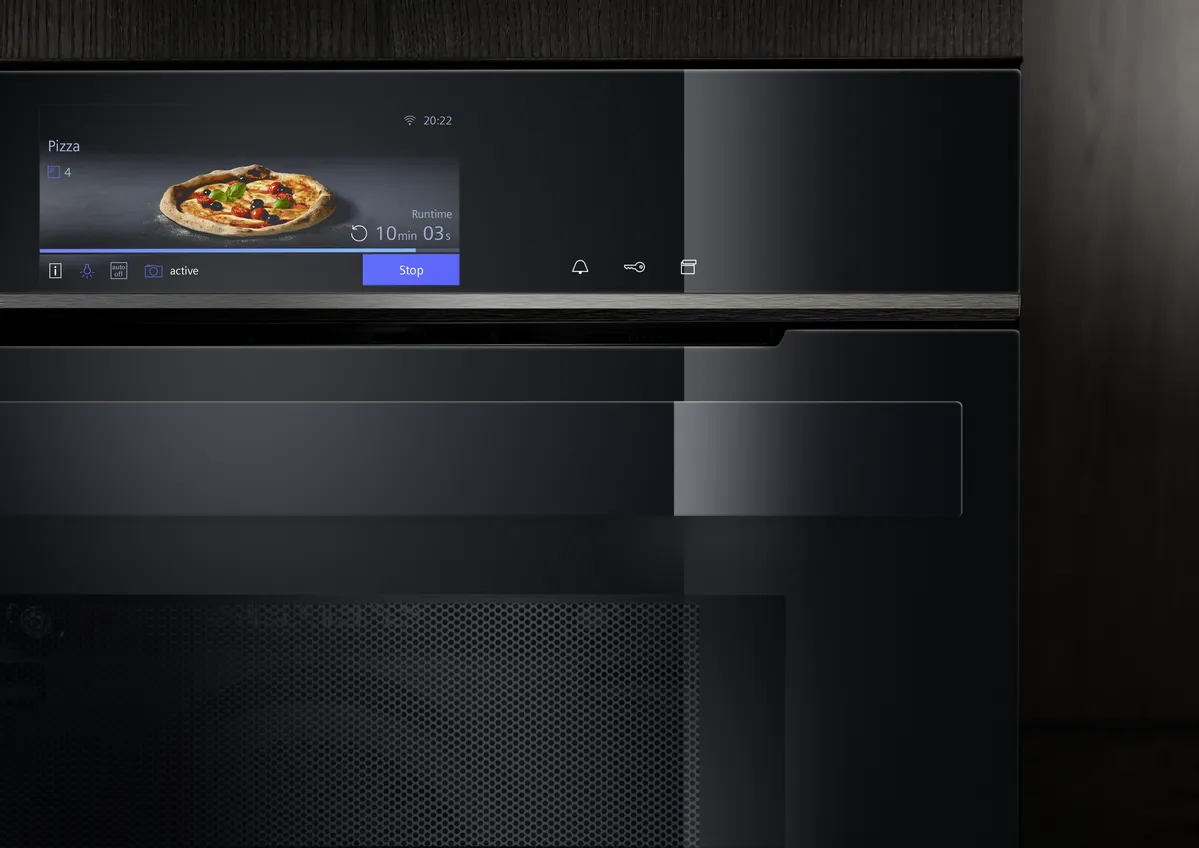 Närbild på ugn och ugnens TFT-Touchdisplay som visar ugnens inställning för Pizzaläge, på displayen syns en perfekt gräddad pizza.