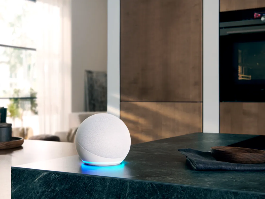 A smart speaker positioned on a kitchen counter, blending seamlessly with the modern kitchen decor.