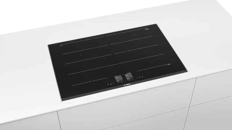 Sleek black induction hob embedded in a white countertop. Features touch controls and minimalist design, conveying modernity and elegance.