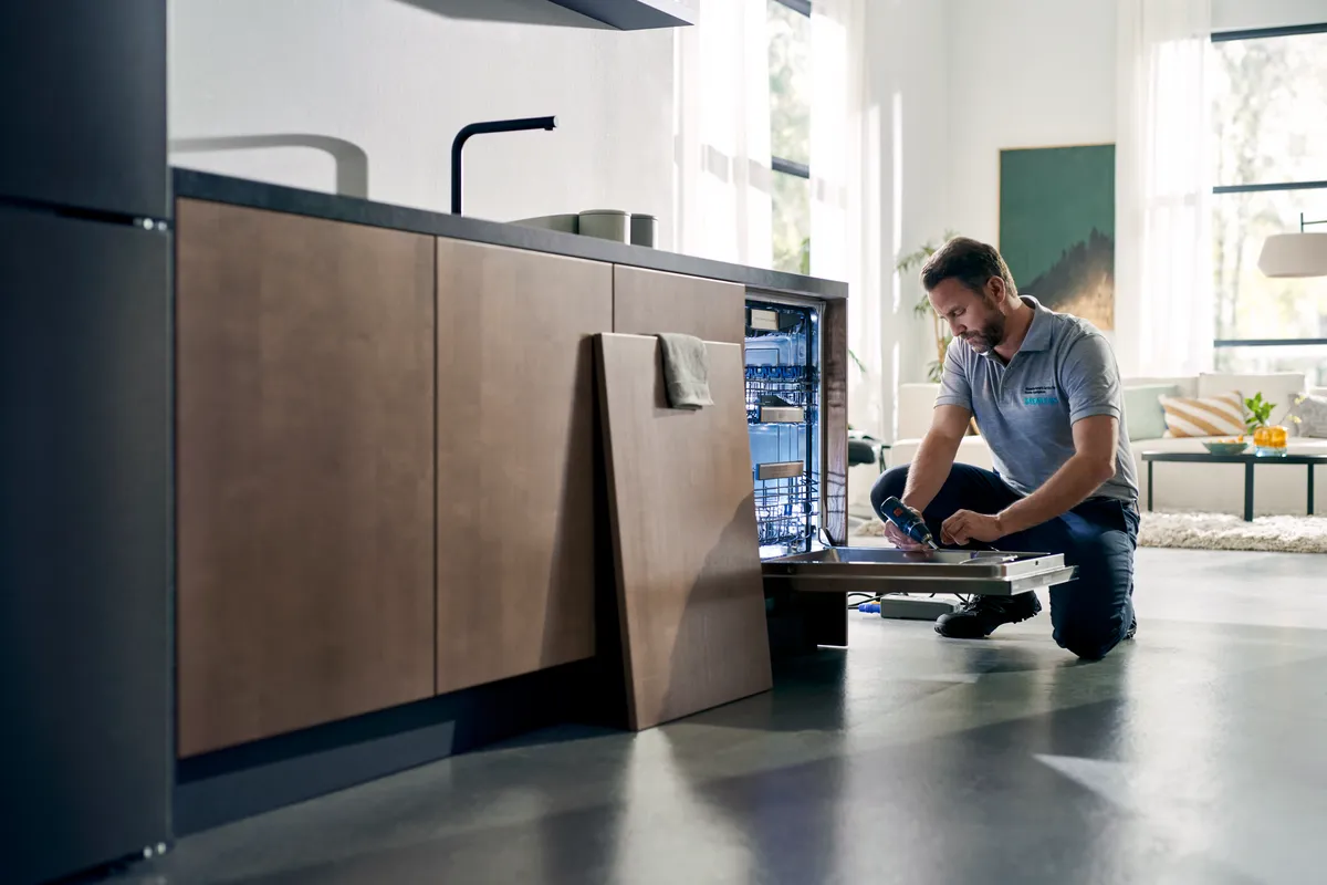 Mann Installation oder Reparatur Geschirrspüler in der modernen Küche.