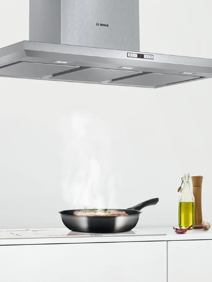 Modern kitchen featuring a wooden island, sleek stools, and minimalist decor.
