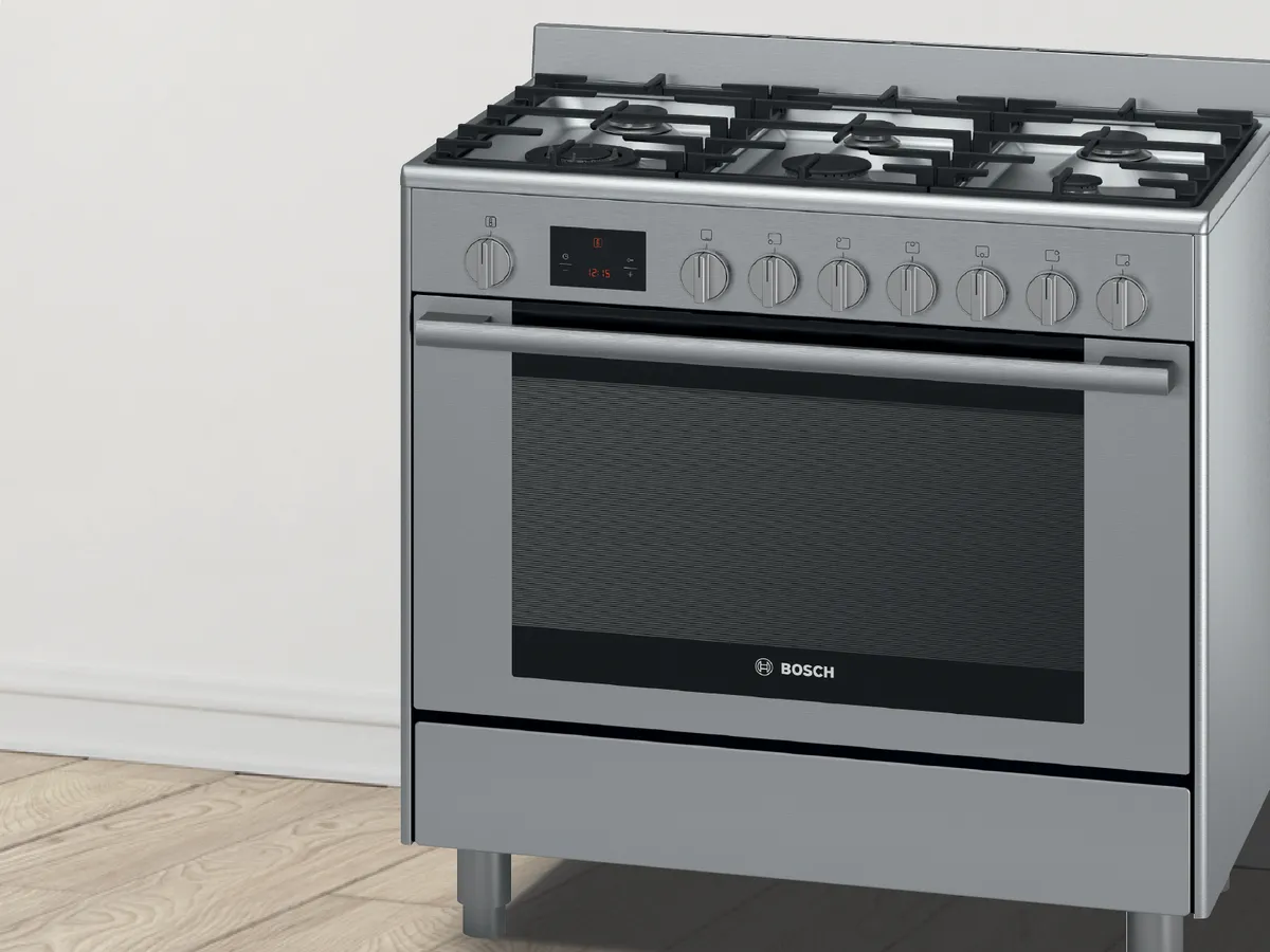 Modern gas stove with one burner lit on a kitchen countertop.