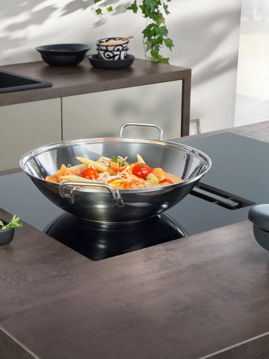 inductionAir Plus cooking field with a wok and adaptive cooking zone