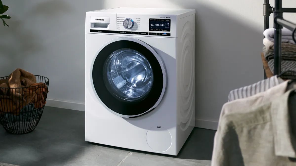 Beyaz ön yük çamaşır makinesi, modern bir evde dijital ekran ile.