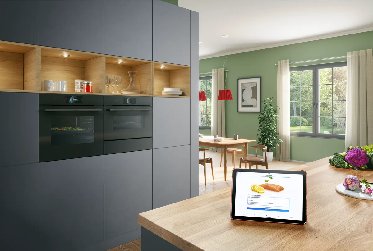 Modern kitchen with gray cabinets, wooden countertop, and tablet displaying nutritional information.