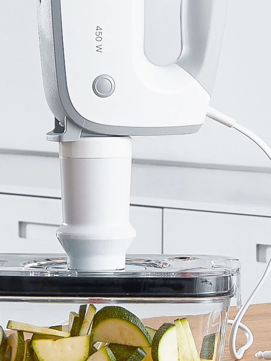 Batedeira manual da Bosch com acessório de selagem a vácuo, conservando as abobrinhas cortadas num recipiente de vidro para uma frescura mais duradoura.