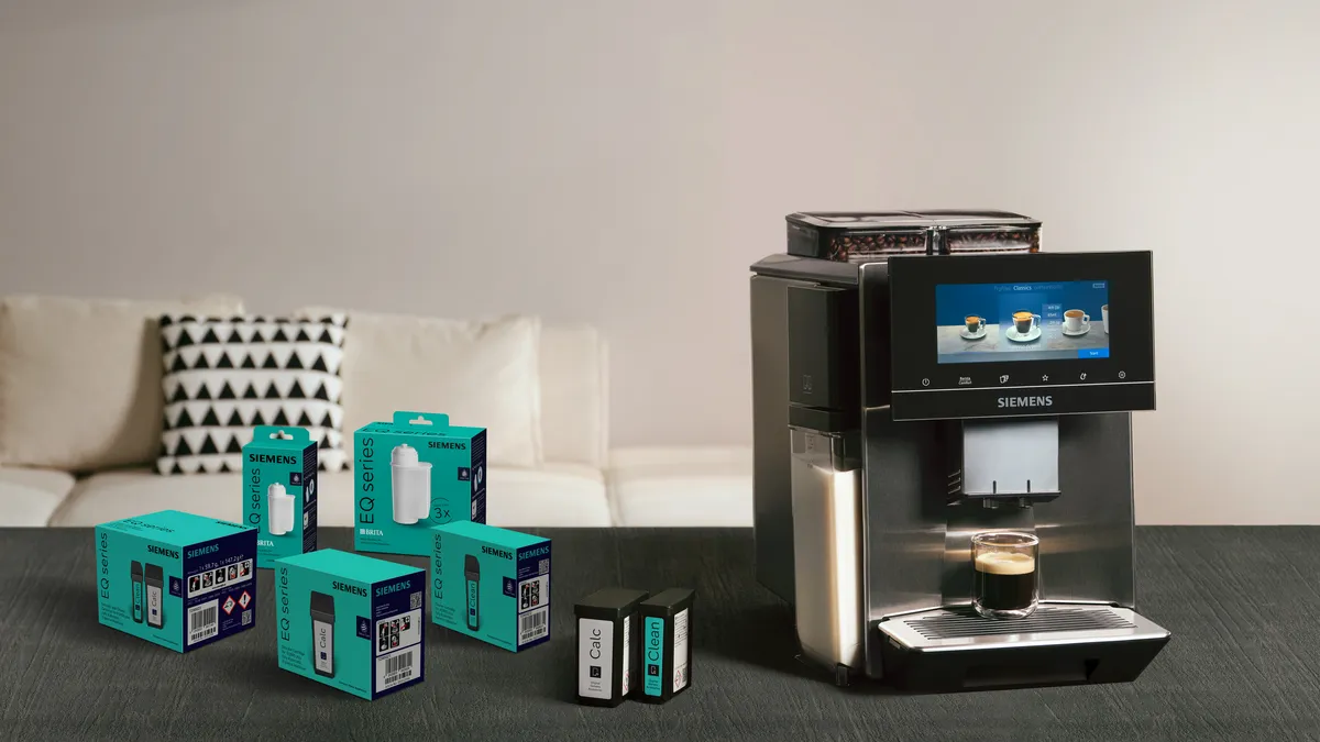 Cleaning and descaling cartridges lie next to the EQ900 plus fully automatic espresso machine on the kitchen worktop