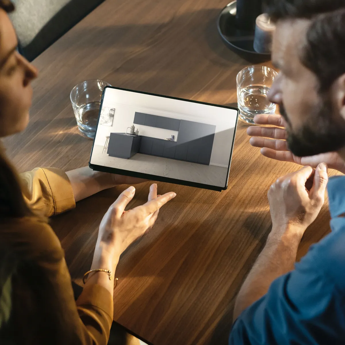  A man and woman are focused on a tablet computer, sharing insights and ideas during their interaction.