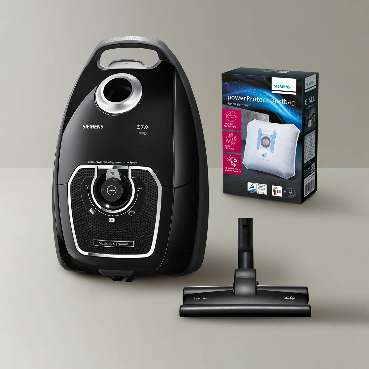 Stofzuiger, voedingsmondstuk, en vacuüm zak doos op een lichte achtergrond.