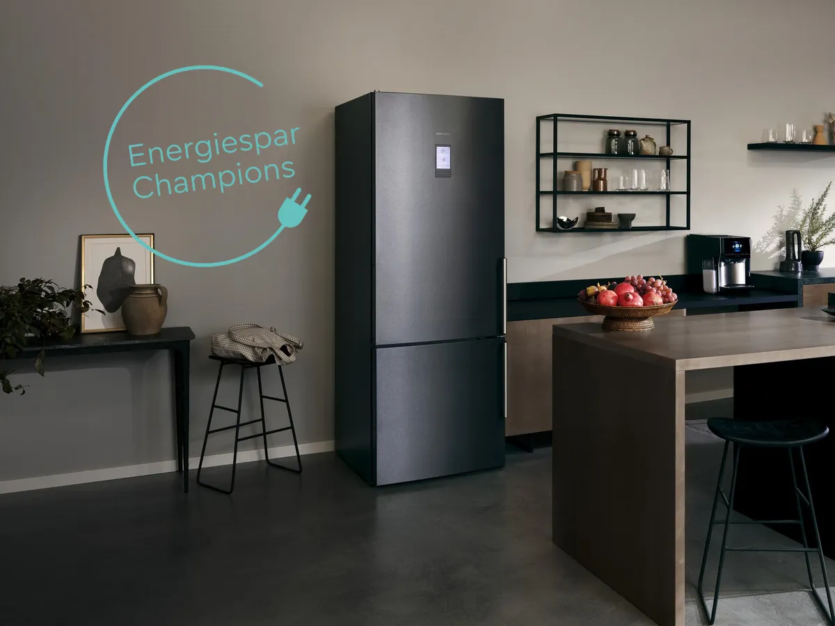 Moderne Küche mit Kühlschrank, Regalen und "Energiespar Champions" Schild.