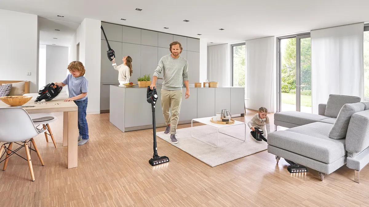 A family of four uses an Unlimited vacuum to clean all levels - cornices, tables and floors – of an open-plan living area.