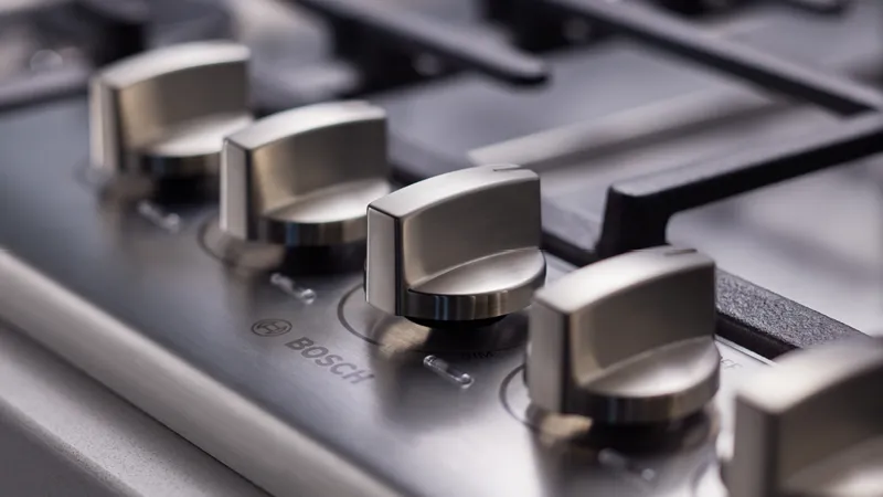 Close-up of Bosch gas stove control knobs on a stainless steel surface, showcasing modern kitchen design and functionality.