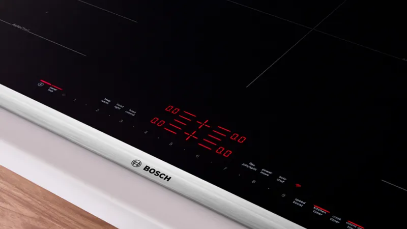 Close-up of a Bosch induction cooktop featuring a sleek black surface with red digital controls and timer functions.