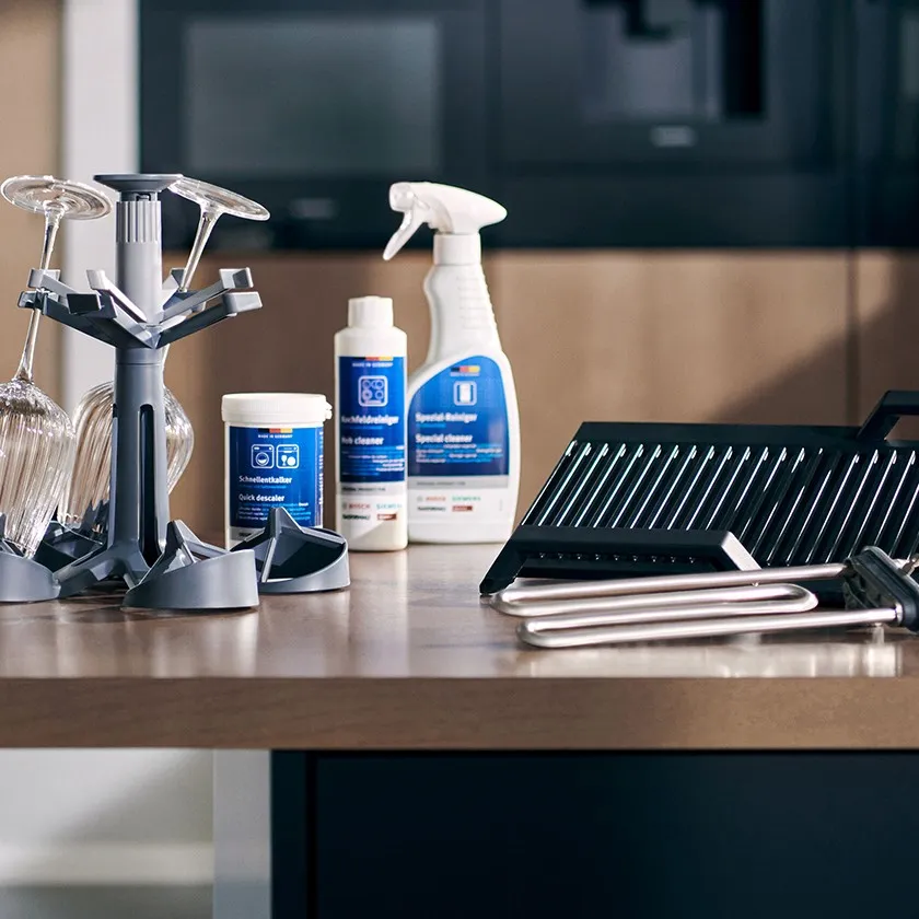 Schoonmaakbenodigdheden, met inbegrip van spuitflessen, borstels en schoonmaakproducten, gerangschikt op een houten oppervlak.