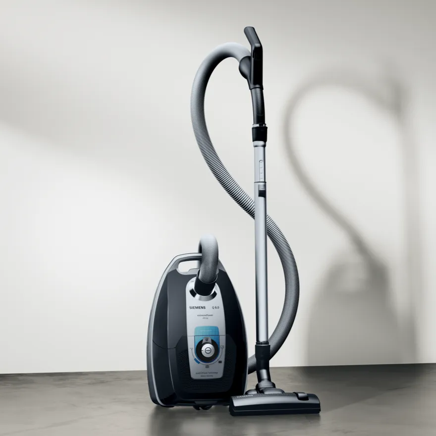 Stofzuiger met slang en toebehoren, zwarte en grijze kleur, op een lichte achtergrond.