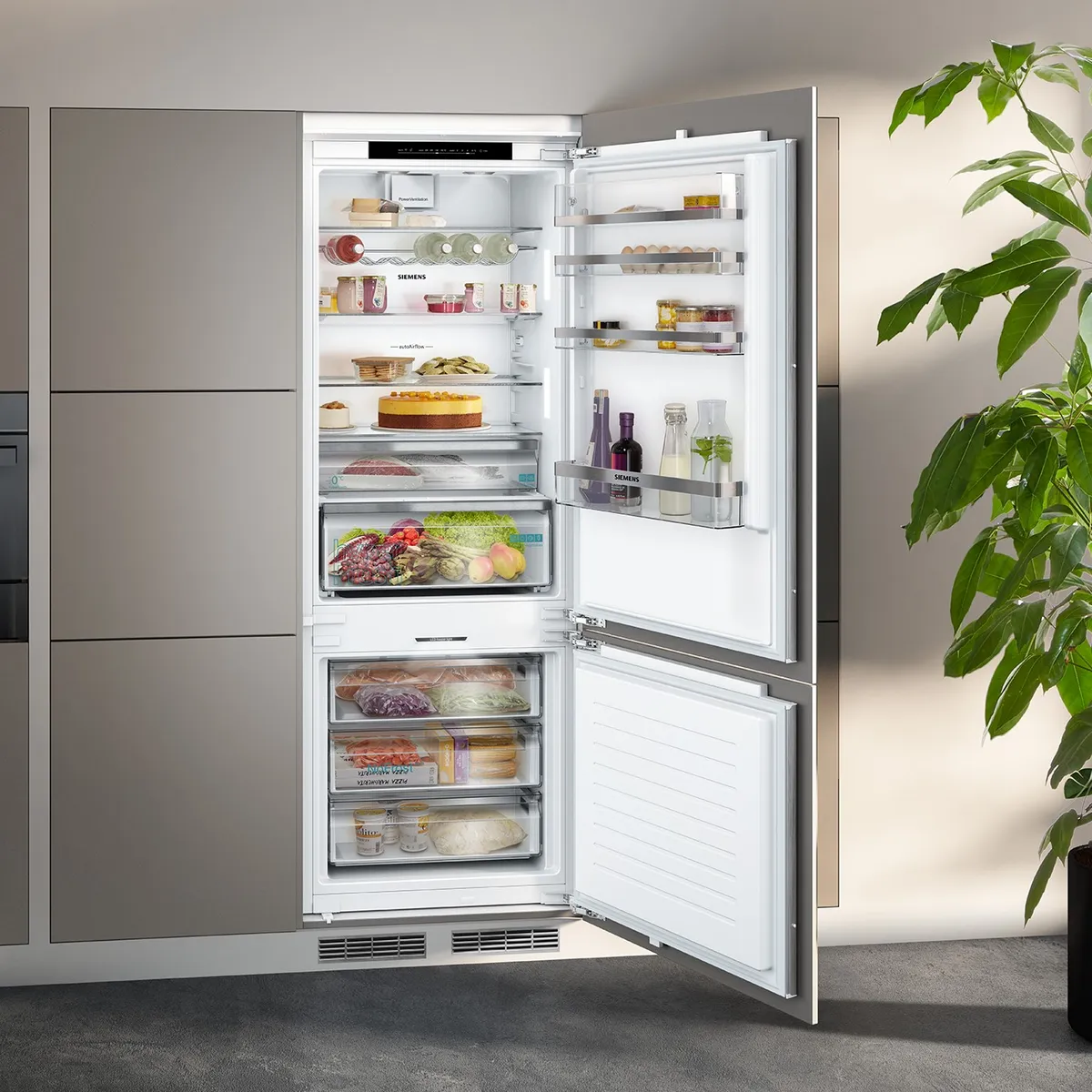 En modern kyl med öppen dörr visar prydligt organiserade hyllor fyllda med mat, drycker och färskvaror.