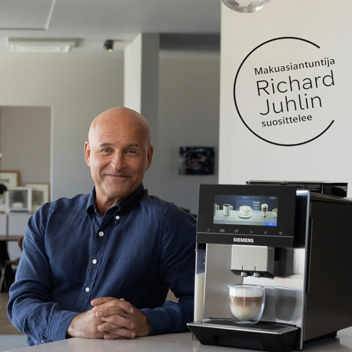 Makuasiantuntija Richard Juhlin hymyilee ylpeänä kahvikoneen vieressä.
