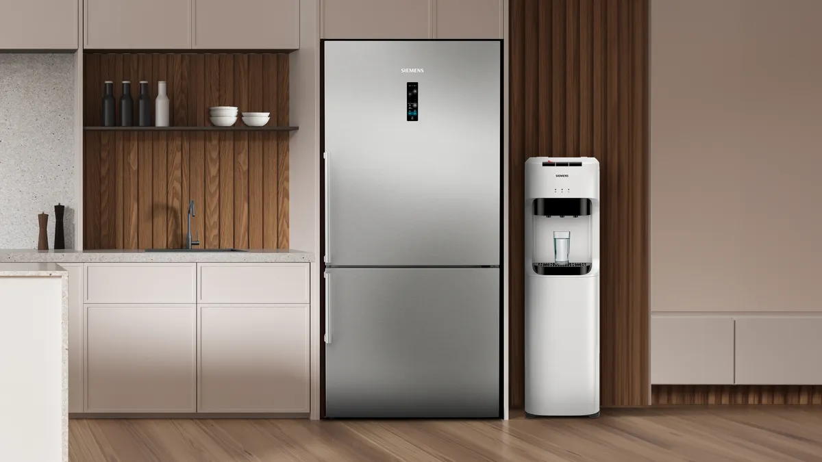 Paslanmaz çelik buzdolabı, dolaplar ve su depolayıcı ile modern mutfak.