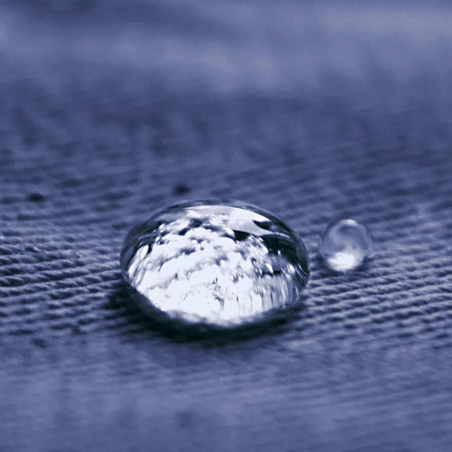 En vattendroppe på ett blått jeanstyg