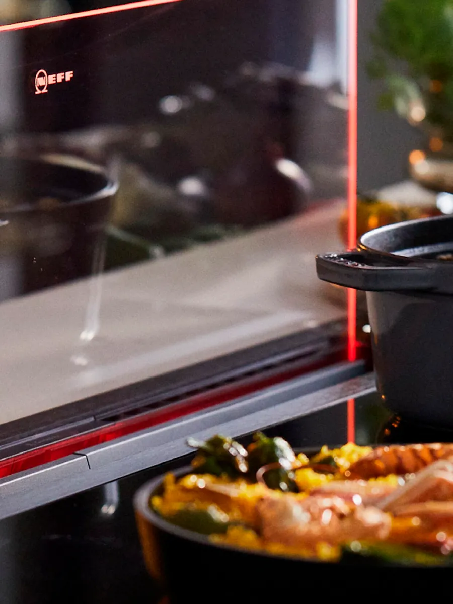 Ο βυθιζόμενος απορροφητήρας σε λειτουργία με δύο σκεύη μαγειρικής μπροστά του.