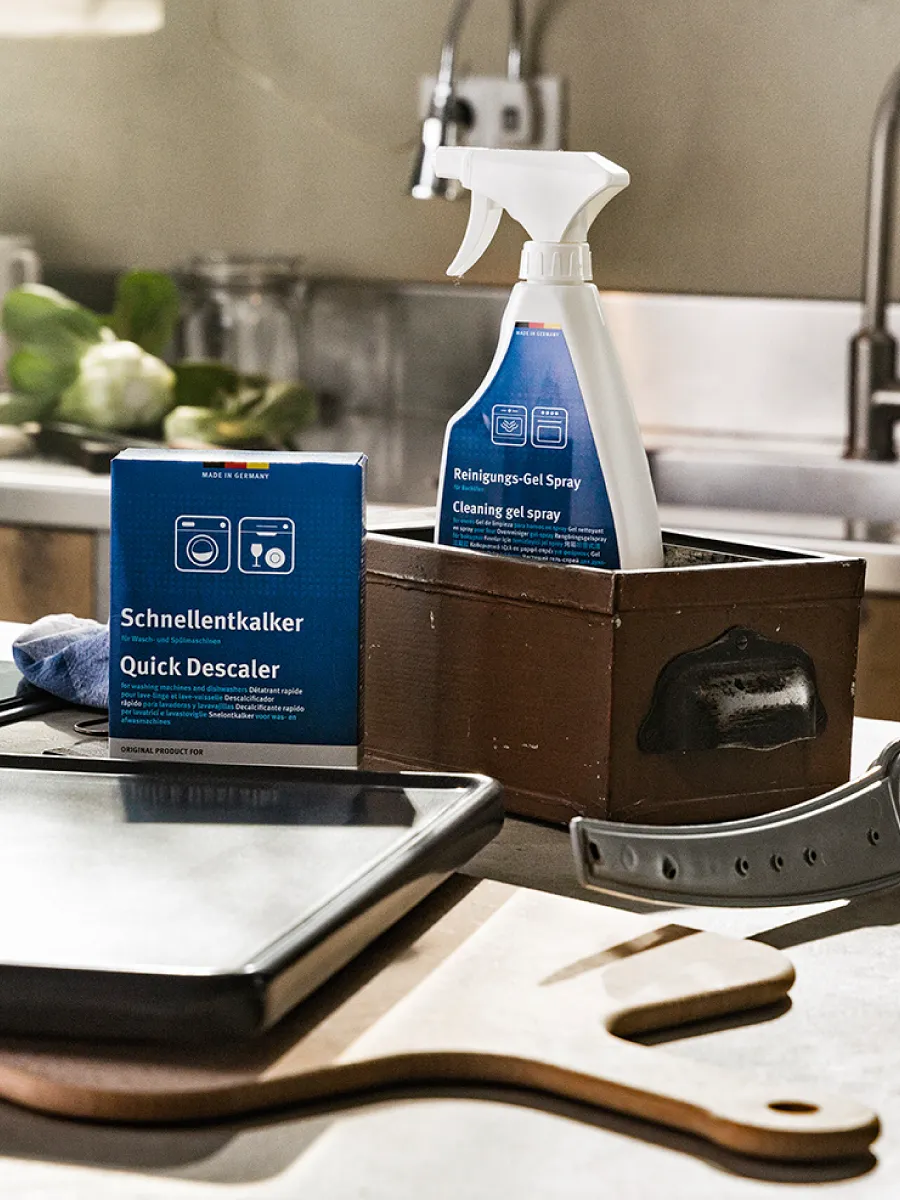 Καθαριστικά NEFF μέσα σε καγέ κουτιά άνω στον πάγκο  της κουζίνας.