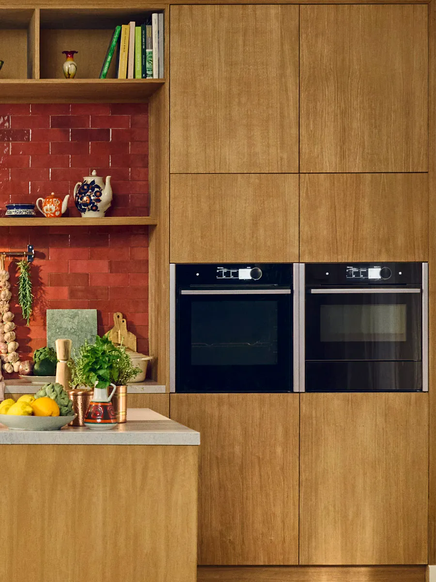 Μια κουζίνα με ξύλινες επιφάνειες και συσκευές NEFF