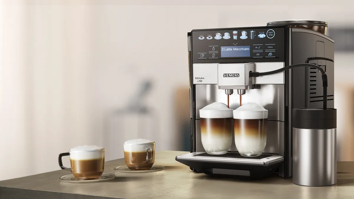 Espresso makinesi bir masada iki bardak kahve ile.