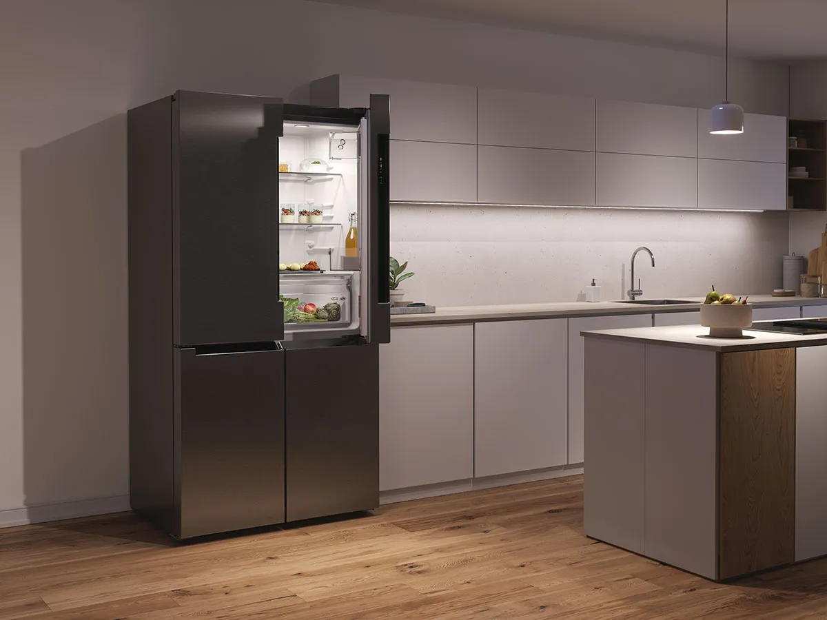Réfrigérateur multi-portes Bosch noir ouvert dans une cuisine moderne éclairée en soirée.