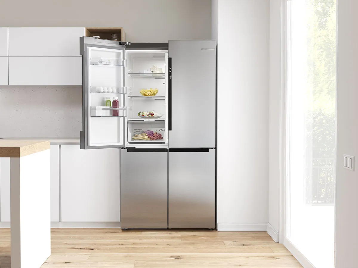 Réfrigérateur multi-portes Bosch en inox, ouvert, dans une cuisine moderne lumineuse.