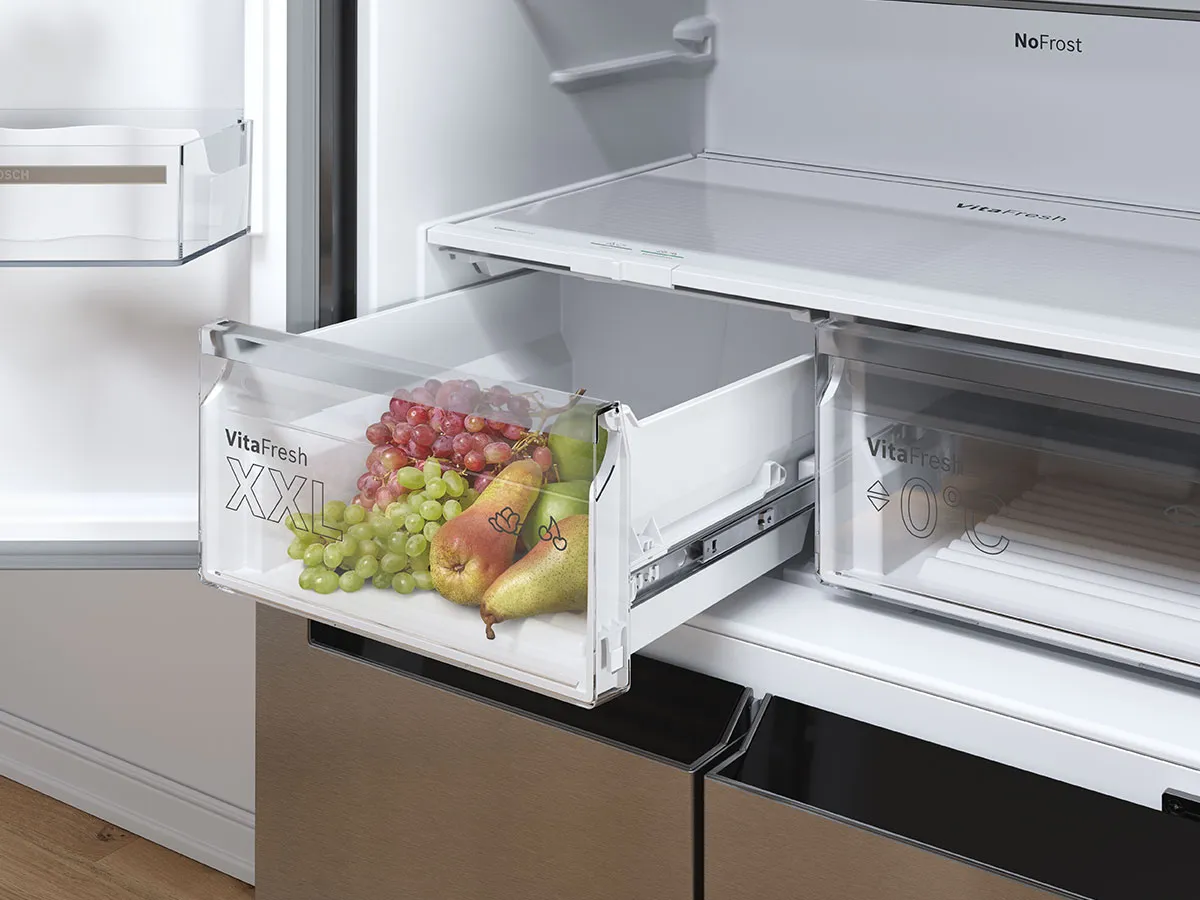 Bac VitaFresh XXL d’un réfrigérateur Bosch rempli de fruits frais comme raisins et poires.