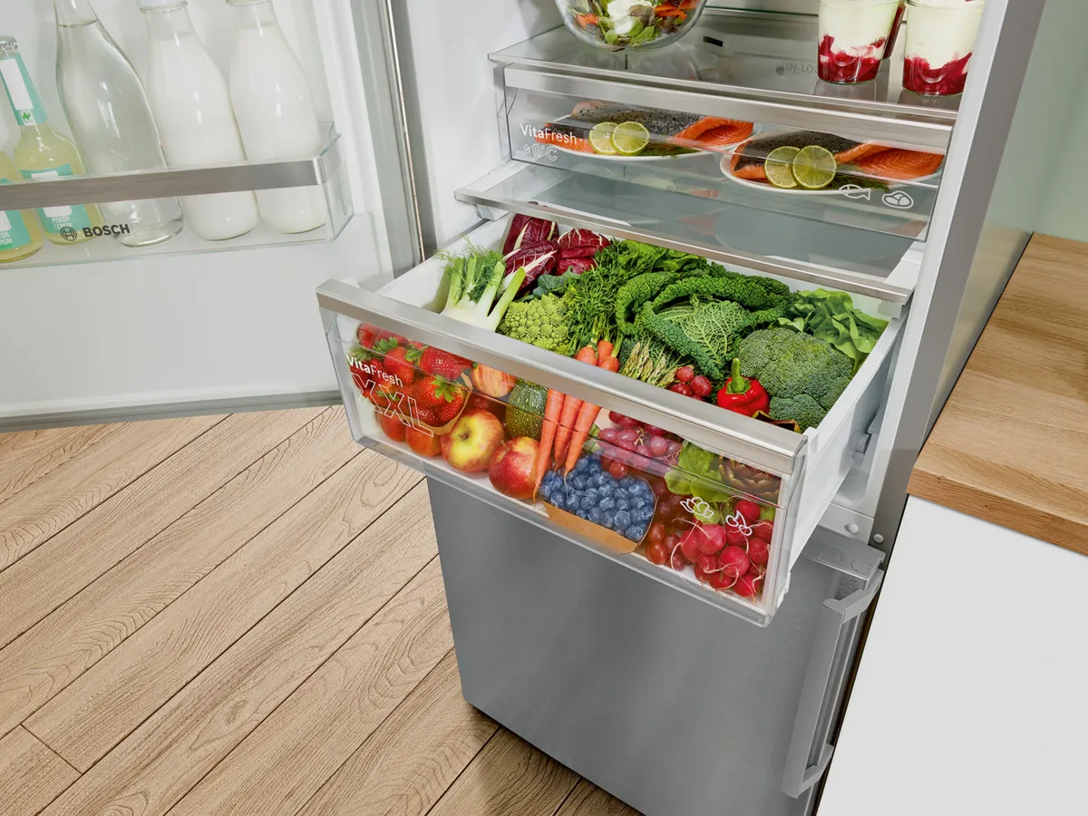 Bac à légumes VitaFresh d’un réfrigérateur Bosch rempli de fruits et légumes frais colorés.