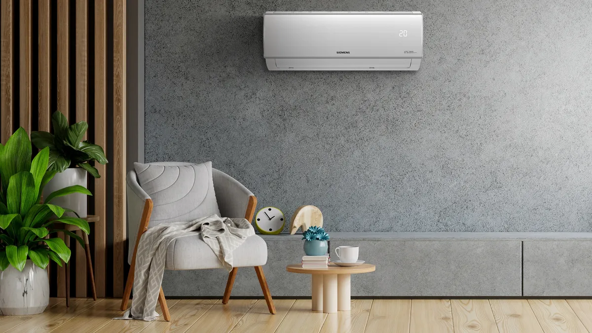 Gri duvar, hava durumu, kolchair, bitkiler ve ahşap zemin ile birlikte oturma odası.