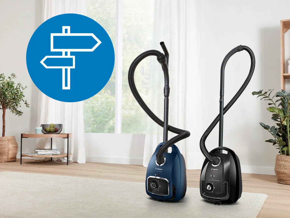 Zwei beutellose Bosch Bodenstaubsauger stehen am Rand eines hellen Teppichs in einem einladenden, hellen Wohnzimmer.