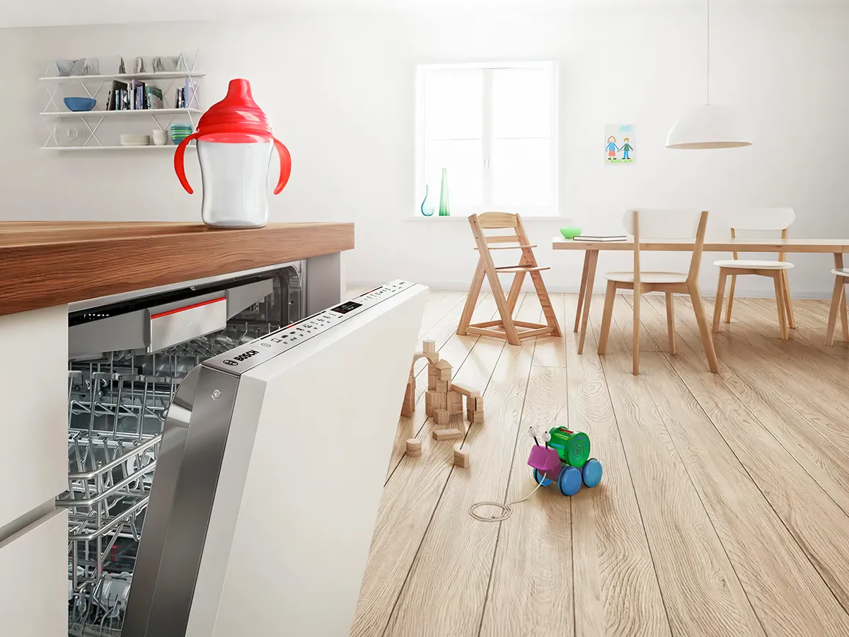 Modern bright kitchen with an open Bosch dishwasher and a spotless clean and perfectly dried sippy cup on the countertop.