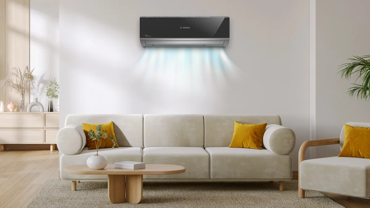 Beyaz kanepe, ahşap kahve masası ve duvardaki klima ünitesi ile Minimalist oturma odası.