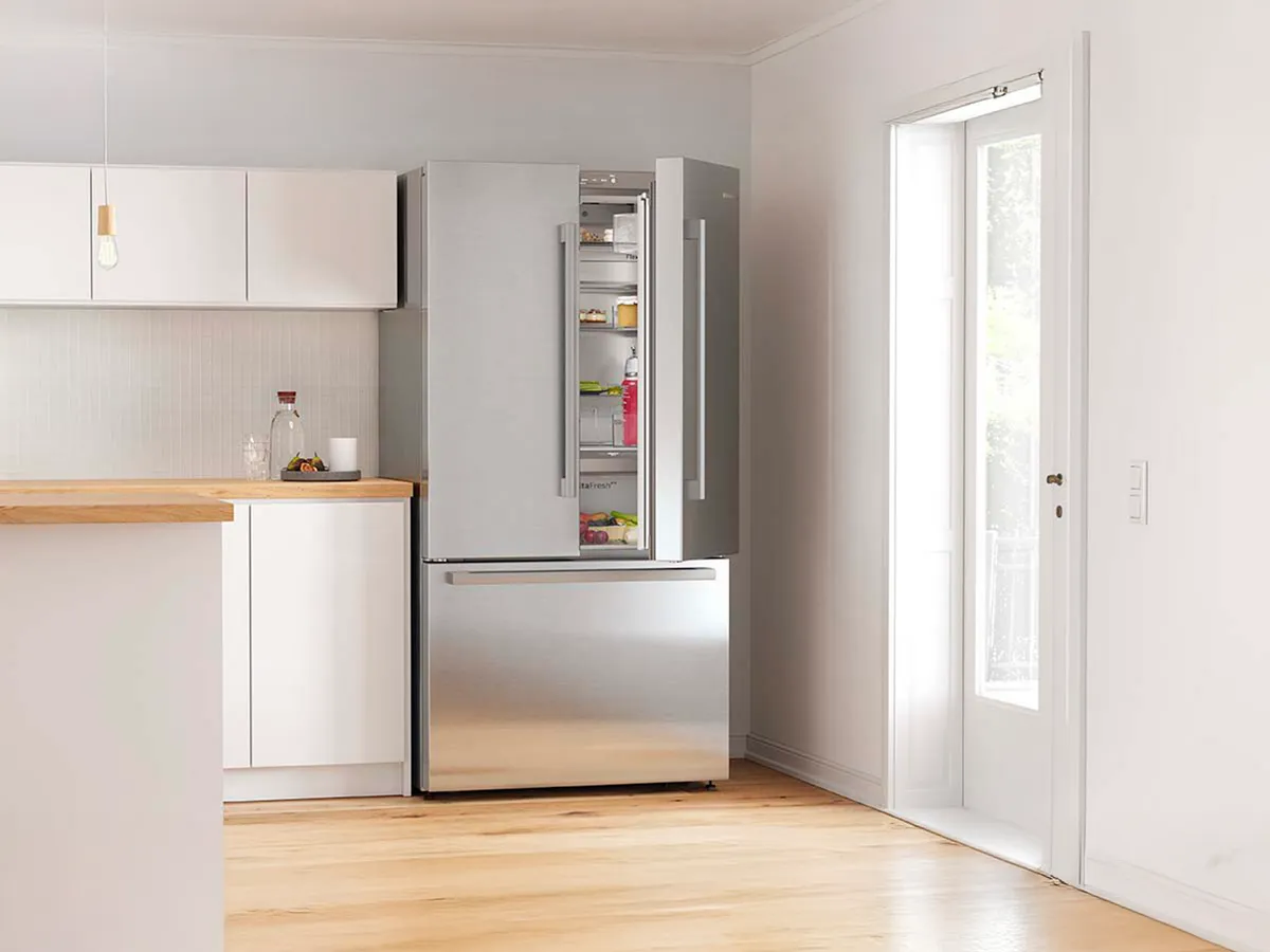 Frigorífico de portas francesas numa cozinha com a porta direita aberta.