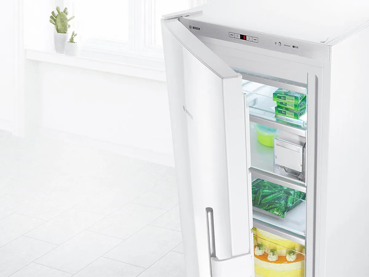 Aparelho independente branco com a porta ligeiramente aberta para mostrar opções de armazenamento flexíveis.
