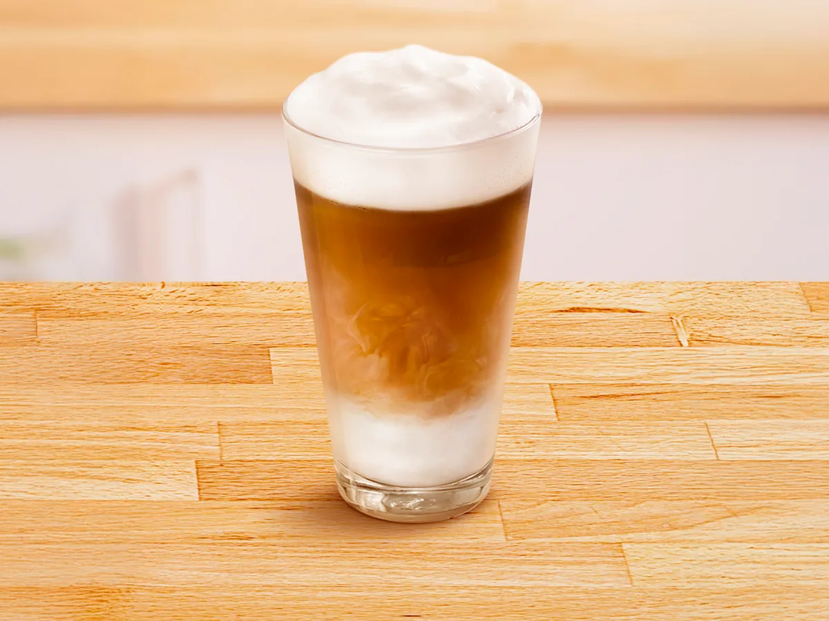 Glass cup filled with flat Latte Macchiato.