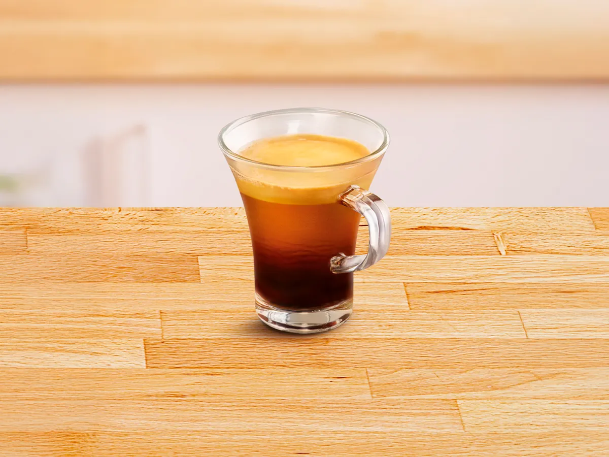 Small glass cup filled with caffé lungo.